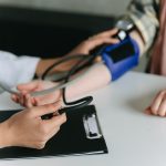 a doctor taking the blood pressure of a person